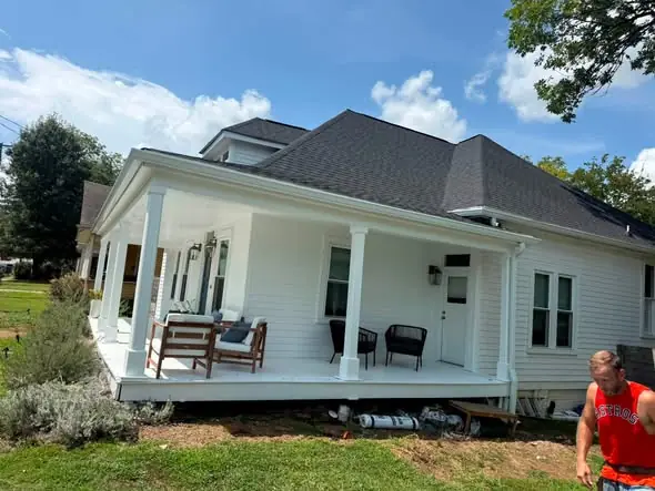 Crew rolling a seamless aluminum gutter along a Chattanooga roof edge
