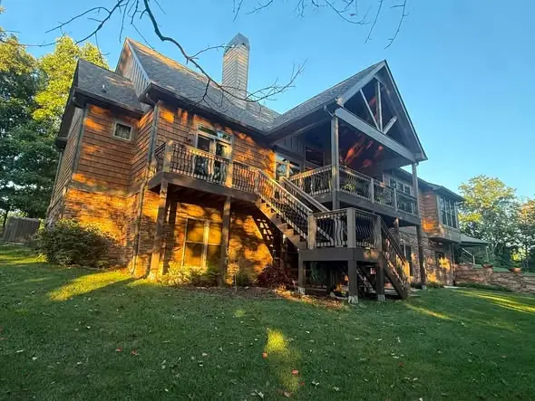 Cedar-shake home with new seamless gutters under a heavy tree canopy